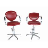 REM; a pair of height adjustable barber's chairs with faux red crocodile upholstery,