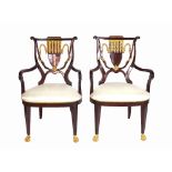 A pair of Regency style hardwood and parcel gilt shield back open armchairs on claw feet,