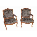 A pair of Louis XVI style stained beech open armchairs on acanthus moulded cabriole supports,