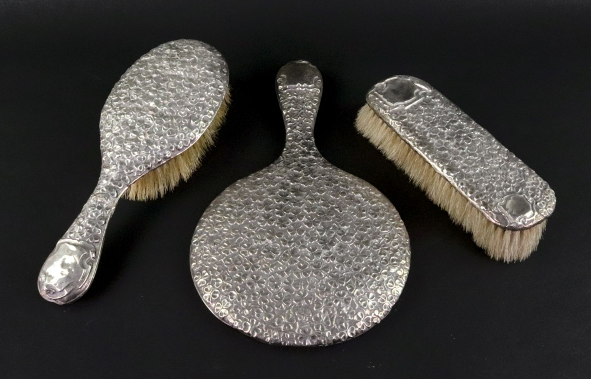 A silver mounted hand mirror, hair and clothes brushes, Nathan & Hayes, circa 1910,