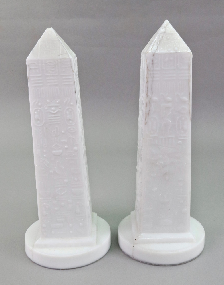 A pair of Victorian white pressed glass obelisks, decorated with hieroglyphics, 22cm high.