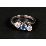 An 18ct white gold, aquamarine and diamond three stone cross-over ring,