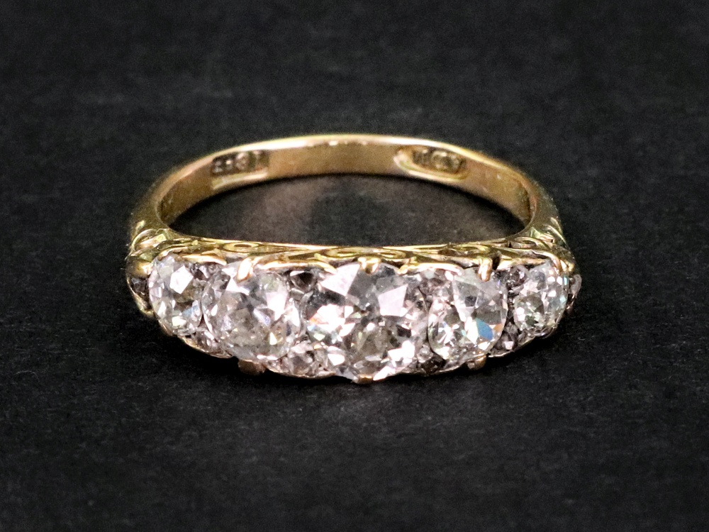 A late Victorian gold and diamond five stone carved half-hoop ring with rose diamond points,