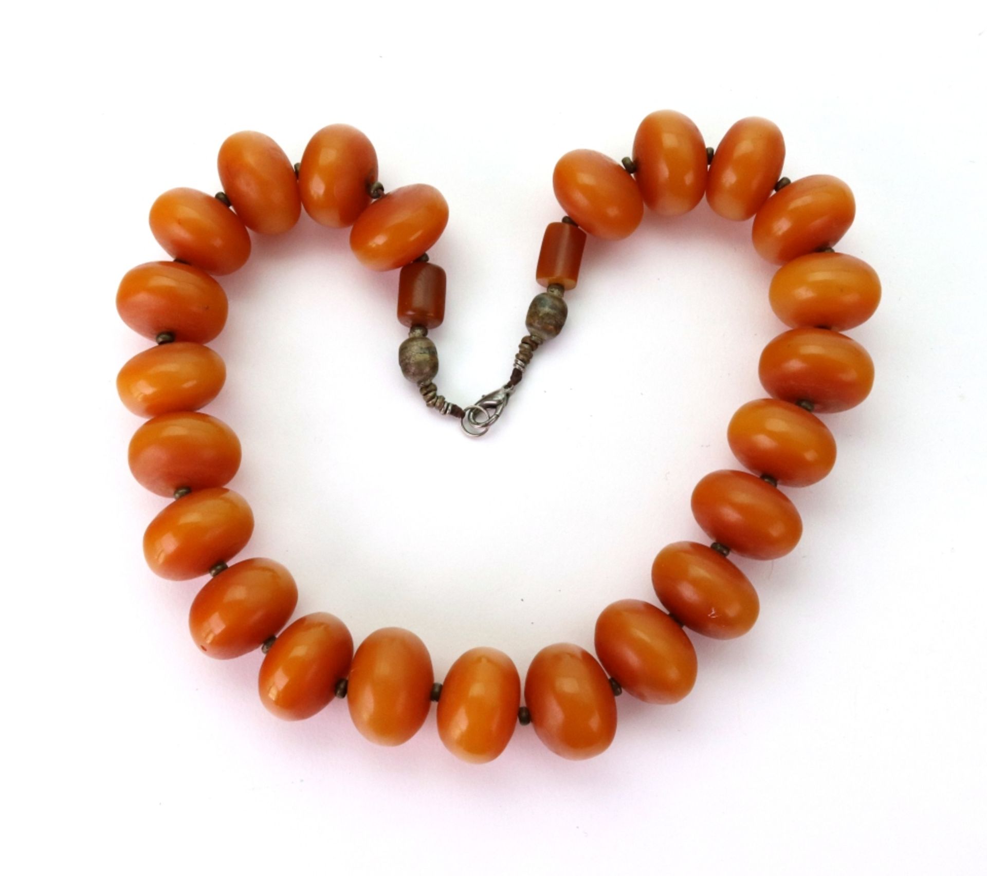 A row of large compressed round reconstituted amber beads.