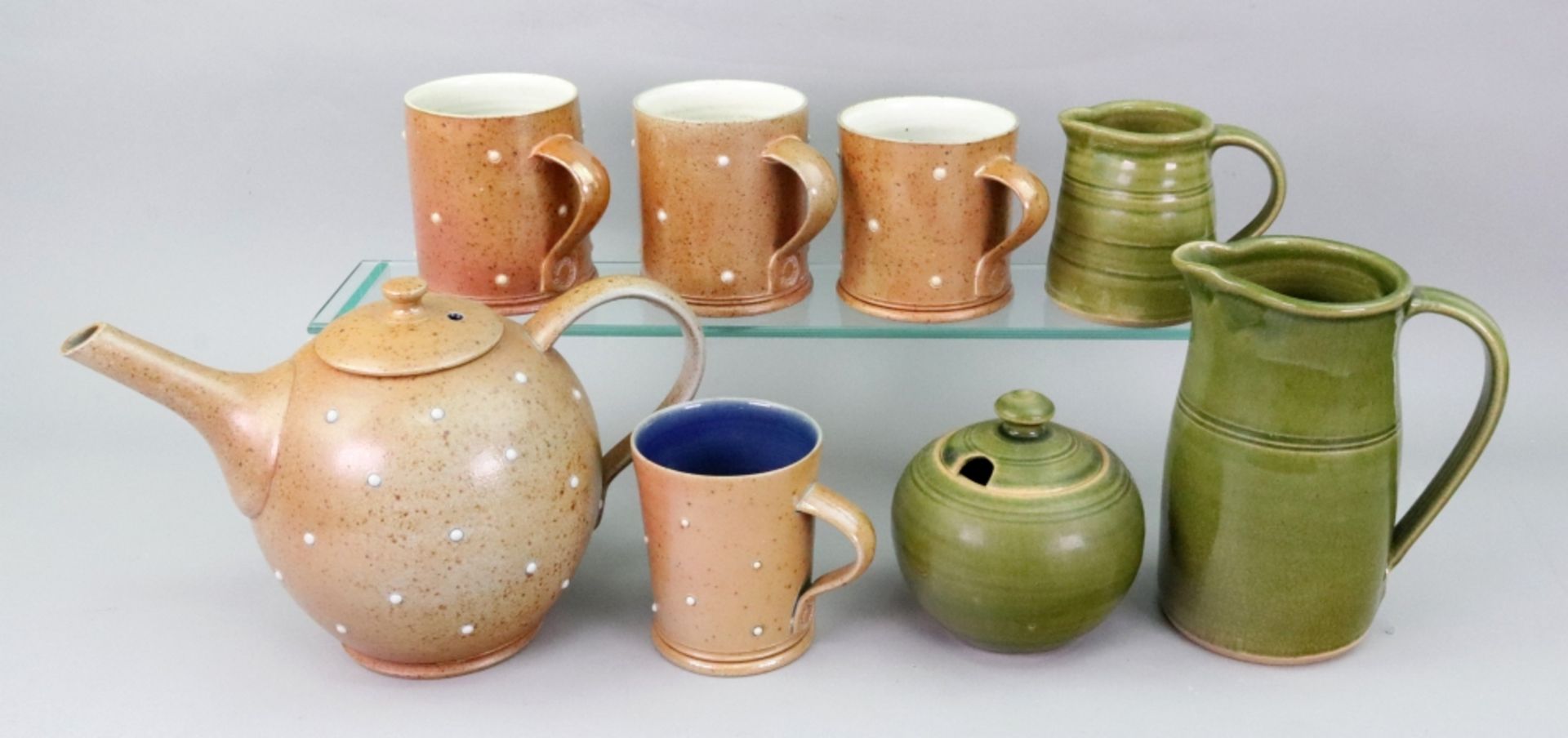 A group of Studio pottery, comprising; a brown stoneware teapot and four mugs, by Alistair Young,