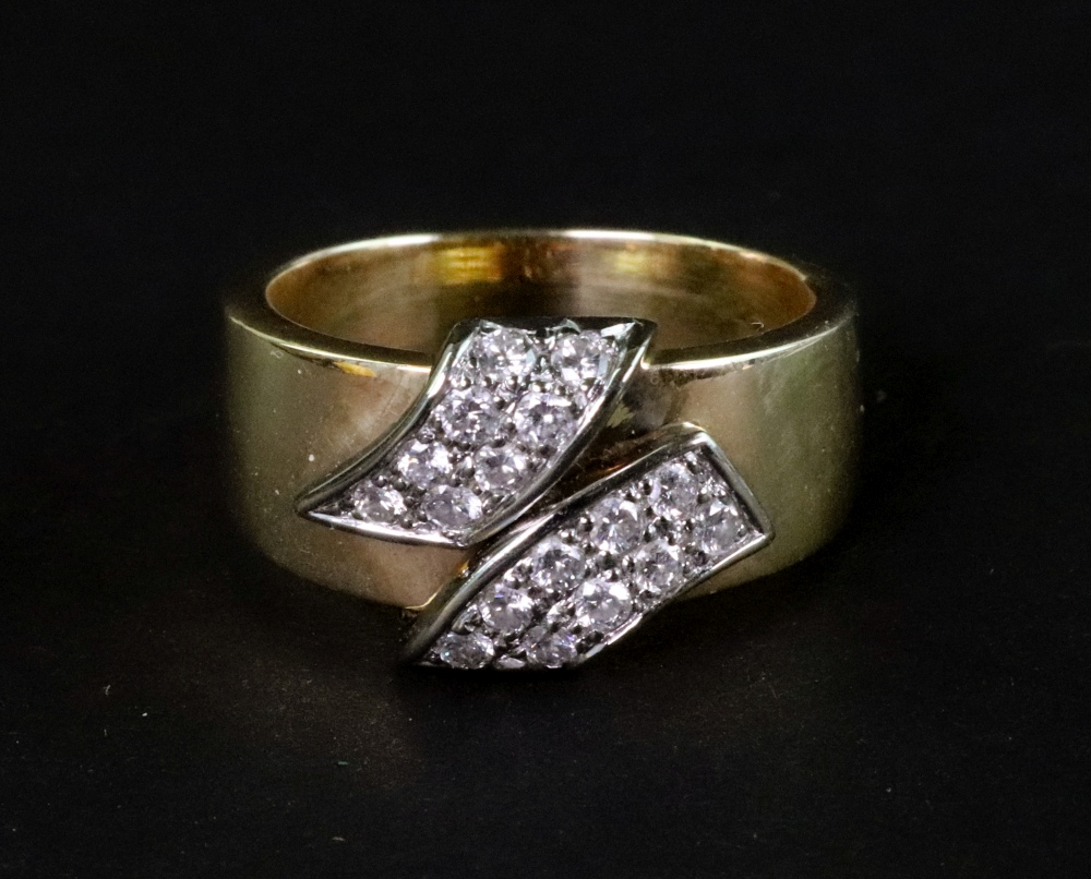 A Continental diamond cross-over scrolls broad band ring,