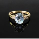 An 18ct gold and oval aquamarine single-stone ring with small two-stone diamond shoulders, size L,