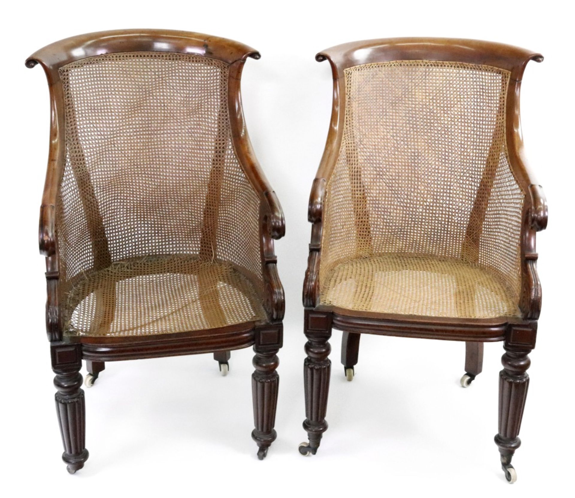 A pair of late Regency mahogany frame bergere chairs, with curved cane panel backs, sides and seats,