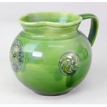 A green glazed earthenware jug, made for Liberty & Co, early 20th century,