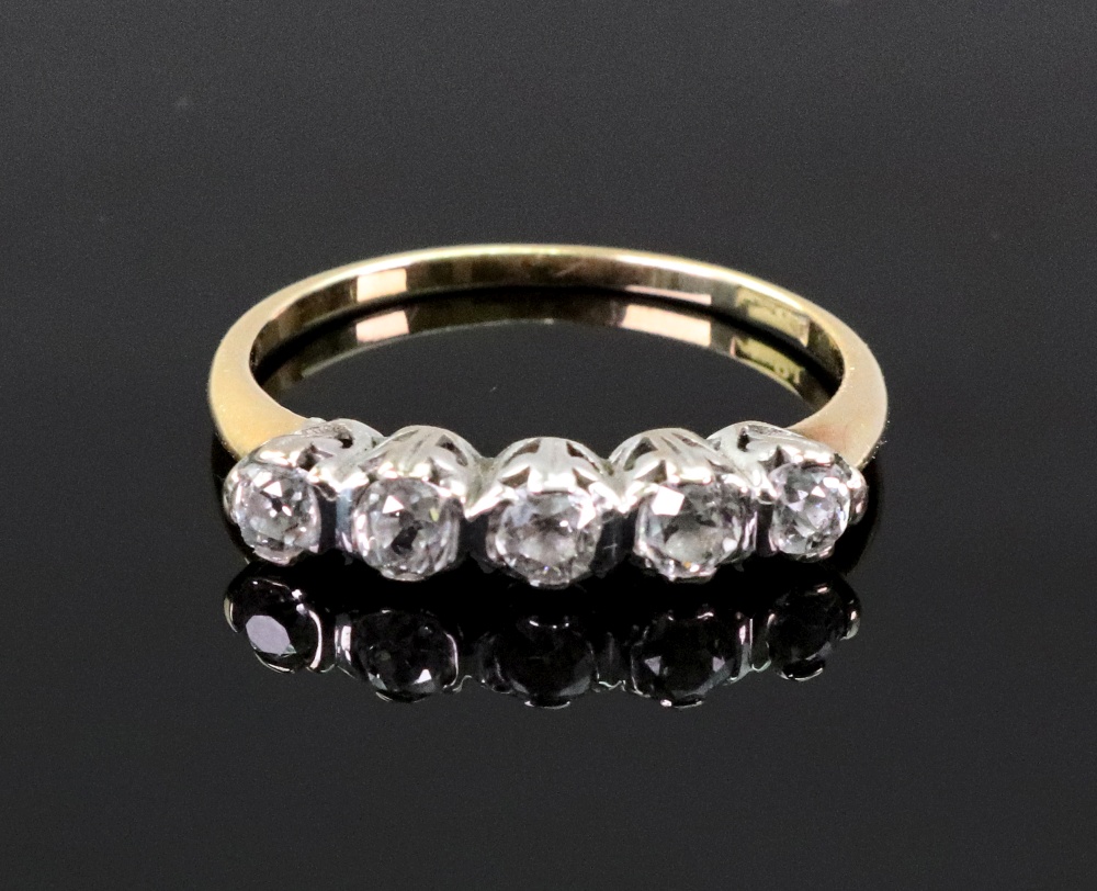 A five stone diamond ring, the claw set stones in white on a yellow gold shank, stamped '18ct',