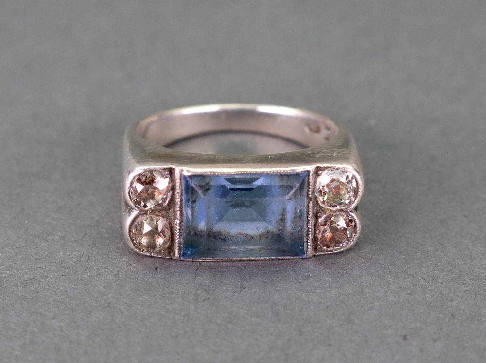 A white gold, blue topaz and diamond ring, the rectangular step cut topaz in millegrain setting,