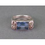 A white gold, blue topaz and diamond ring, the rectangular step cut topaz in millegrain setting,