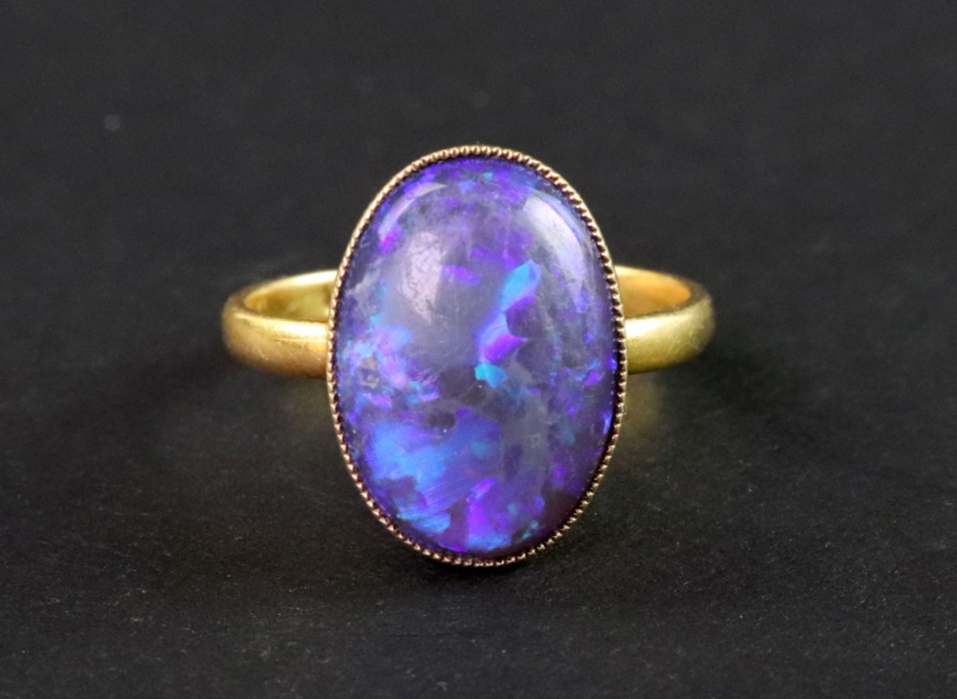 A late Victorian gold and black opal single stone ring, the oval cabochon approx.