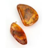 An amber pendant, the amber mounted with a top jump ring and another piece of amber (2).