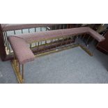 A modern brass club fender with upholstered seat over pillared supports and a stepped kerb,