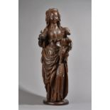 A 17th century carved oak figure group of a Madonna and child, 84cm high.