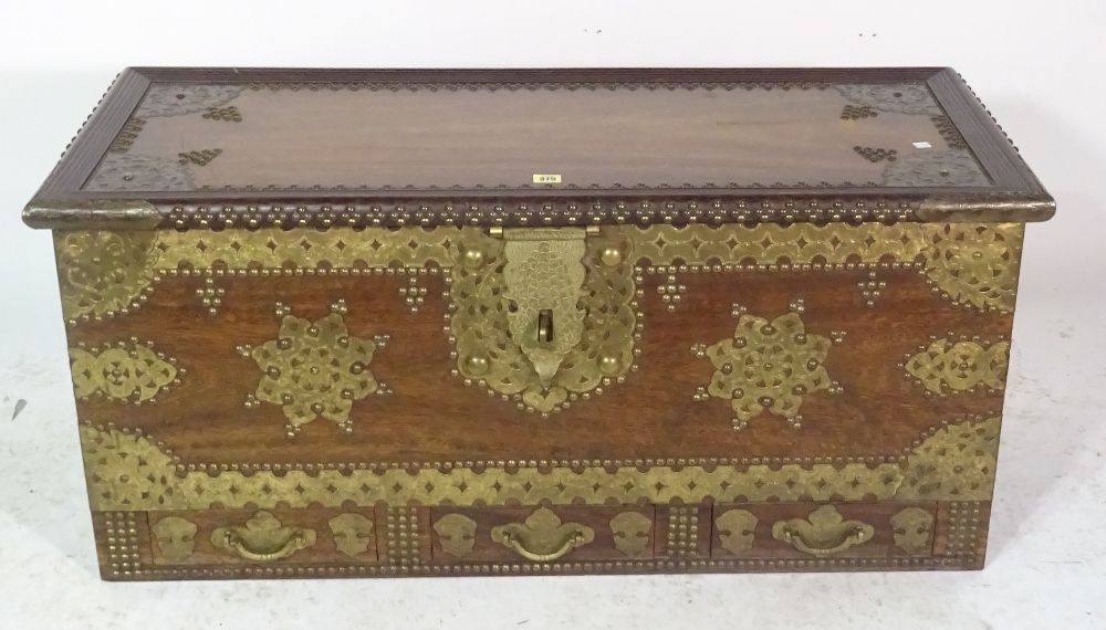 A 20th century African hardwood and brass bound studded trunk with three drawers,