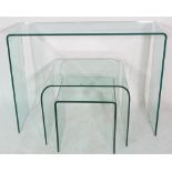 A nest of three glass side tables, the largest 100cm wide x 75cm high.