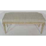 A Louis XVI style rectangular footstool on tapering fluted supports, 92cm wide x 42cm high.