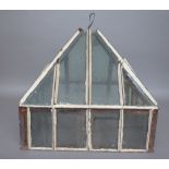 A Victorian wrought iron garden cloche of square form with a raised tapering roof,