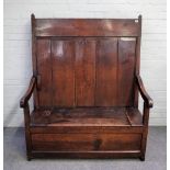 An 18th century oak plank back box seat open arm settle, 117cm wide x 144cm high.