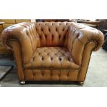 A 20th century brown leather Chesterfield type armchair, 110cm wide x 75cm high.