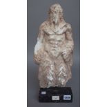 An alabaster carved figure of a mythological male, possibly Zeus on a hardstone rectangular plinth,