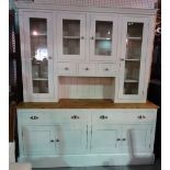 A 20th century painted pine dresser with glazed Delft rack over a pair of drawers and cupboards,