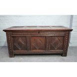 An 18th century oak coffer, the side pivot four panel lid over carved triple panel front,