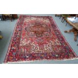 A Heriz carpet Persian, the madder field with a bold angular medallion,