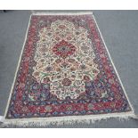 An Esfahan rug, Persian, the ivory field with a madder medallion, pale indigo spandrels,