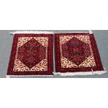 A pair of Baluchistan mats, with seven guls, ivory and bird spandrels, 76cm sq, (2).