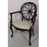 An early 20th century mahogany spiderweb back open armchair on cabriole supports,