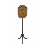 A 19th century mahogany pole screen with floral needlework pommel on three outswept supports,