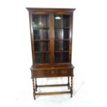 An 18th century style oak display cabinet with three geometric moulded drawers,