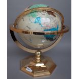 A modern gilt metal table globe decorated with semi-precious hardstones on an octagonal foot,