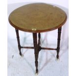 An Edwardian walnut circular side table on ring turned supports, 58cm wide x 63cm high.