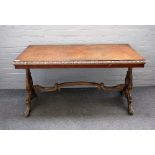 A Victorian parcel gilt figured walnut rectangular centre table on carved trestle end standards and