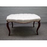 A 19th century mahogany framed footstool of serpentine outline on cabriole supports,