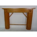 A 20th century beech fire surround with fluted decoration, 158cm wide x 115cm high,