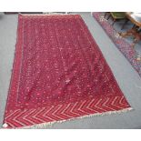 A Turkman embroidered flatweave, the madder field with an allover design of hooked motifs,