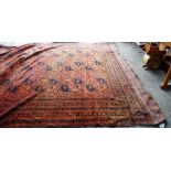 An Afghan carpet, the madder field with three columns of seven large guls,