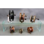 A collection of six fishing reels: including three wooden reels, one stamped Carters of London,