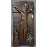 A 19th century carved walnut plaque depicting the crucifixion,
