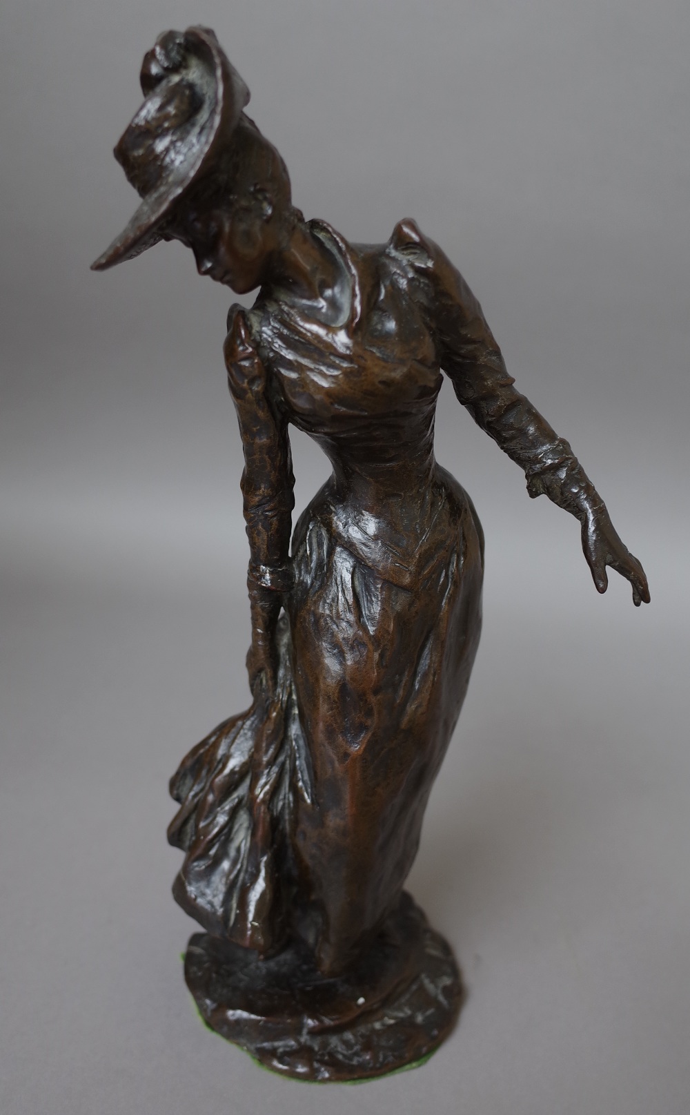 A bronze figure of a Victorian lady, indistinctly signed and dated 1892,