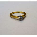 A gold and diamond single stone ring, claw set with a circular cut diamond, detailed 18 CT,