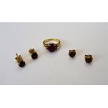 A gold and garnet ring, mounted with an oval carbuncle garnet to the centre,