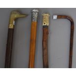 A Chinese malacca walking cane with embossed silver pommel, 89cm, a bamboo riding crop,