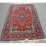 An Isfahan carpet, burgundy red field with circular mandala shaped medallion,