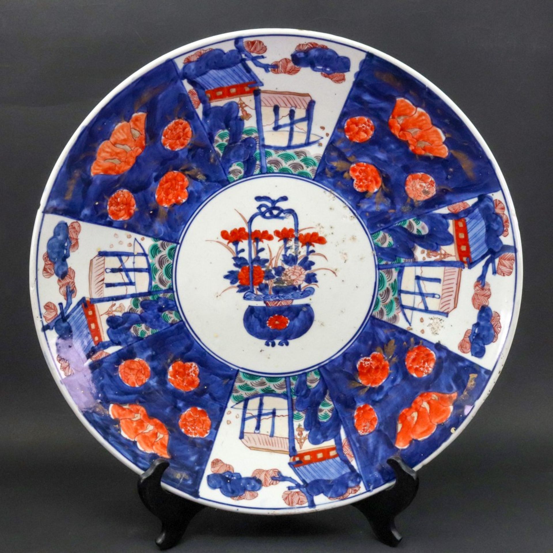 A large Japanese Imari dish, Meiji period, painted with a central basket of flowers,
